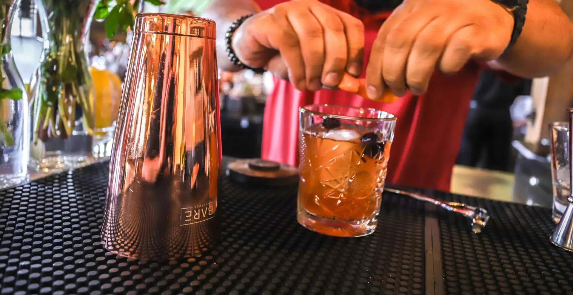 Bartender prepares a drink behind the bar.