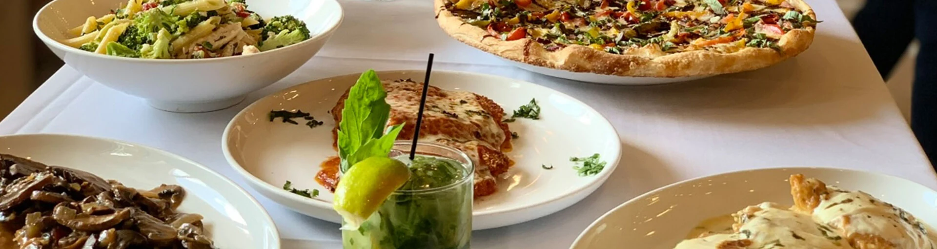 Italian dishes and drinks are served on a table.