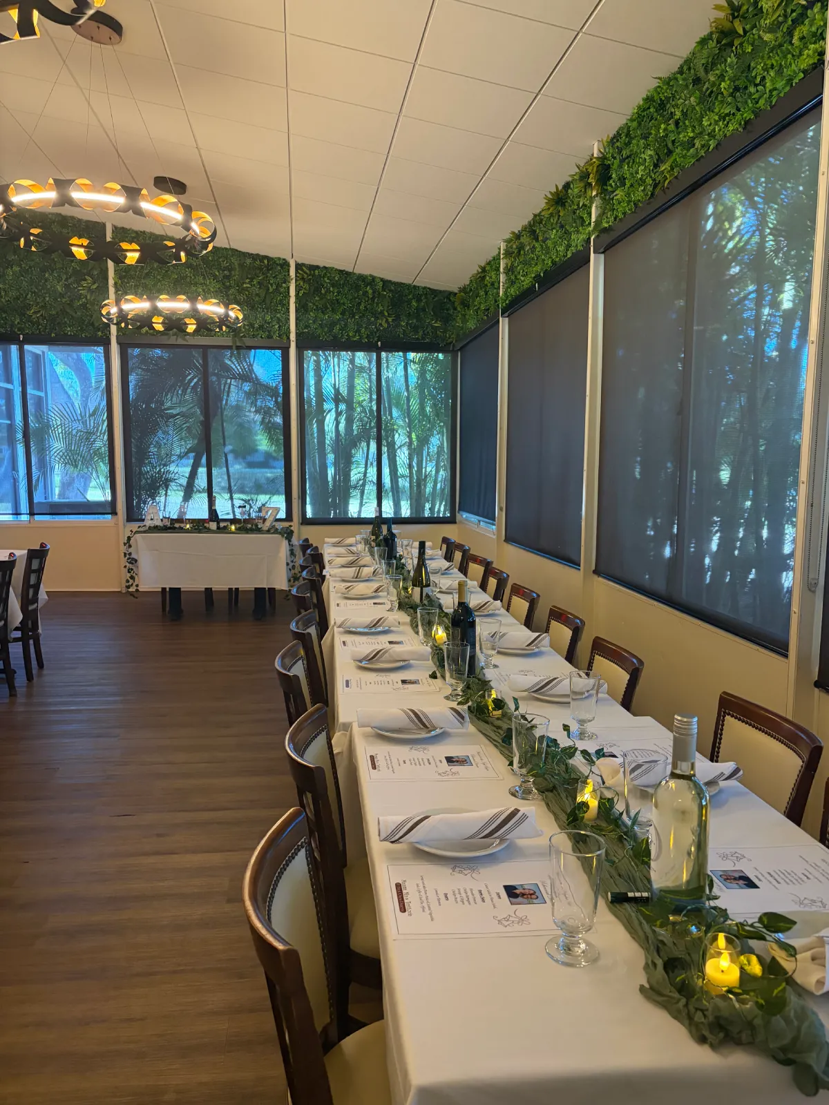 Side angle view of private event table with plates and wine bottles.