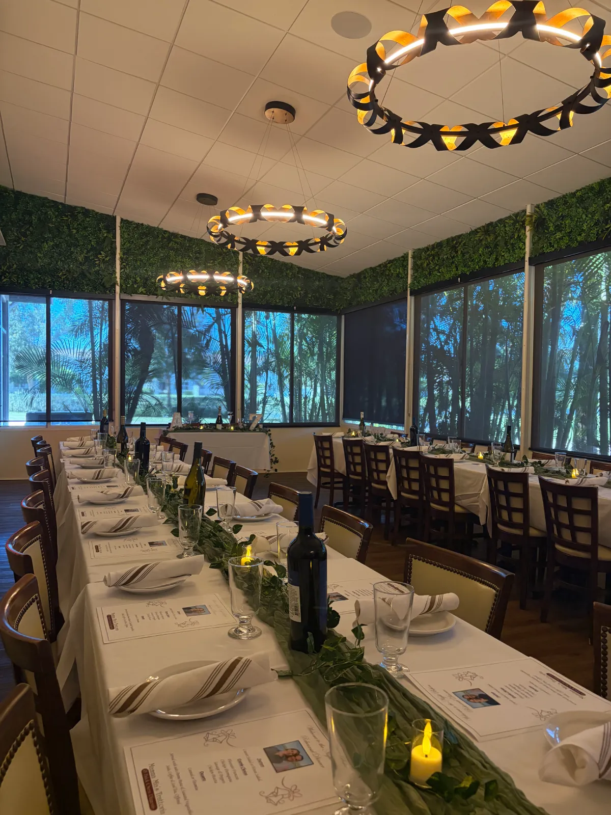 Side angle view of private event table with plates and wine bottles.